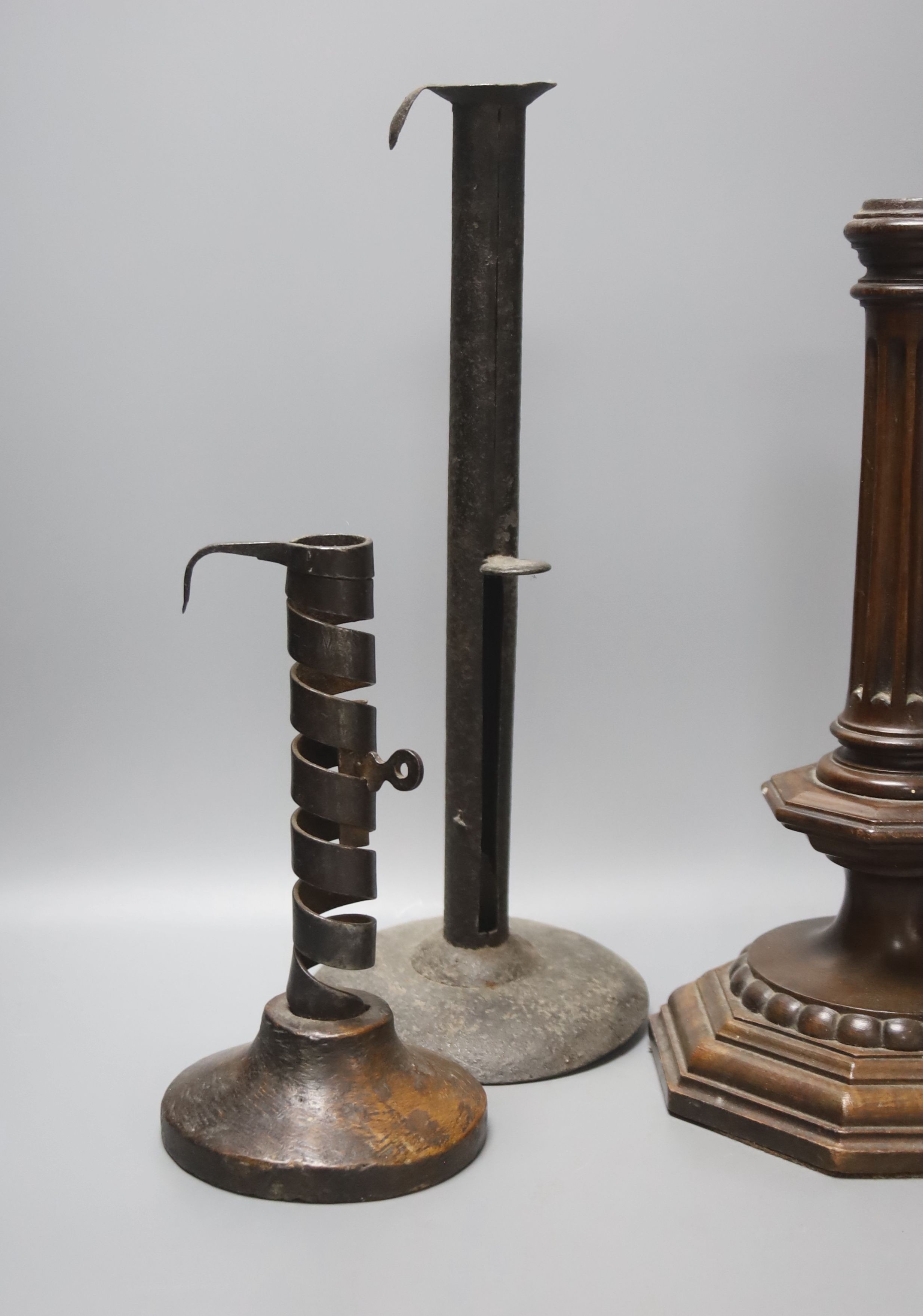 A wrought iron taperstick, a pair of iron telescopic candlesticks, a spiral candlestick, all Georgian and a 17th century style carved wood candlestick (5)